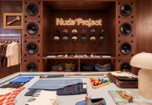 Interior of Nude Project’s Amsterdam store featuring Kubrick-inspired design elements and minimalist streetwear displays