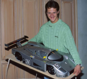 Michael Schumacher standing beside a 1:5 scale Mercedes Sauber C9 model in Stuttgart, 1992, early in his racing career