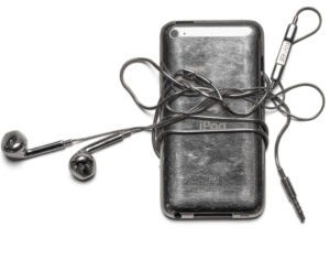 Stainless steel RacerPods jewelry shaped like earbuds, styled as a necklace and ear accessory from the Spring 2025 collection