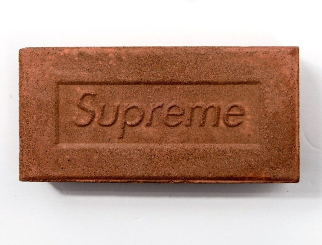 A red clay brick embossed with the Supreme logo, symbolizing streetwear’s shift from design to cultural branding