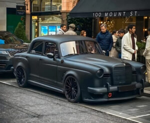 Matte black 1961 Mercedes Ponton restomod with AMG C63 chassis and widebody stance, parked on a city street