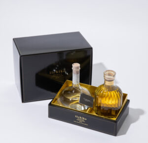 Minimalist iichiko Flask Bottle and amber-toned iichiko Special displayed on a wooden table, evoking quiet haute