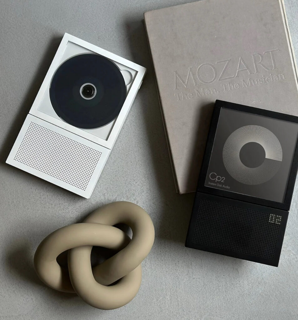 Modern Elevate Stand showcasing CD player with album cover on display, minimalist design, and built-in speaker
