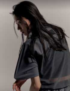 Model wearing New Balance Grey Summer 2025 apparel in an urban Chinese setting, showcasing lightweight grey streetwear