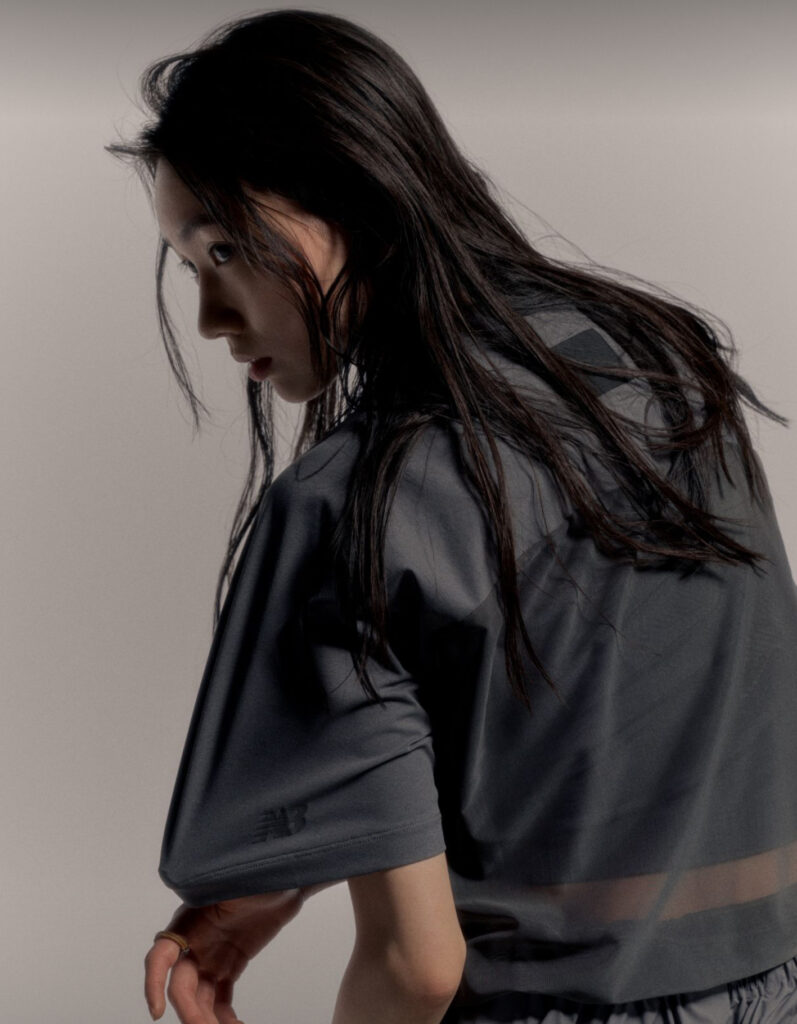 Model wearing New Balance Grey Summer 2025 apparel in an urban Chinese setting, showcasing lightweight grey streetwear