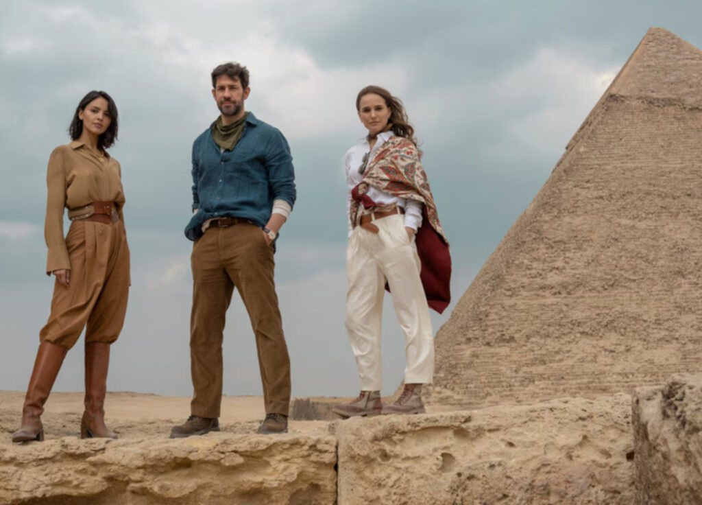 John Krasinski and Natalie Portman face off in a cave illuminated by glowing spores in Fountain of Youth on Apple TV+