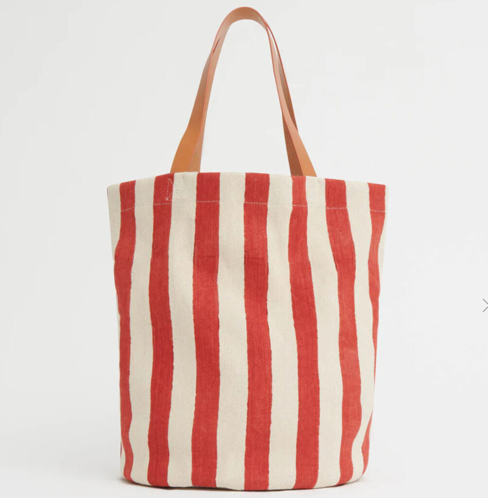 A limited edition Mansur Gavriel Pascucci Tote with hand-stamped blue and red stripes and leather handles on display