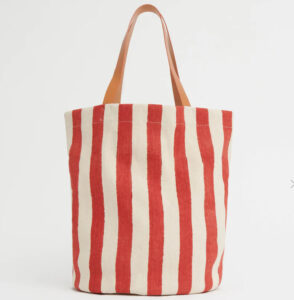 A limited edition Mansur Gavriel Pascucci Tote with hand-stamped blue and red stripes and leather handles on display