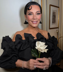 Kris Jenner portrait image holding a white rose clasp in both hands