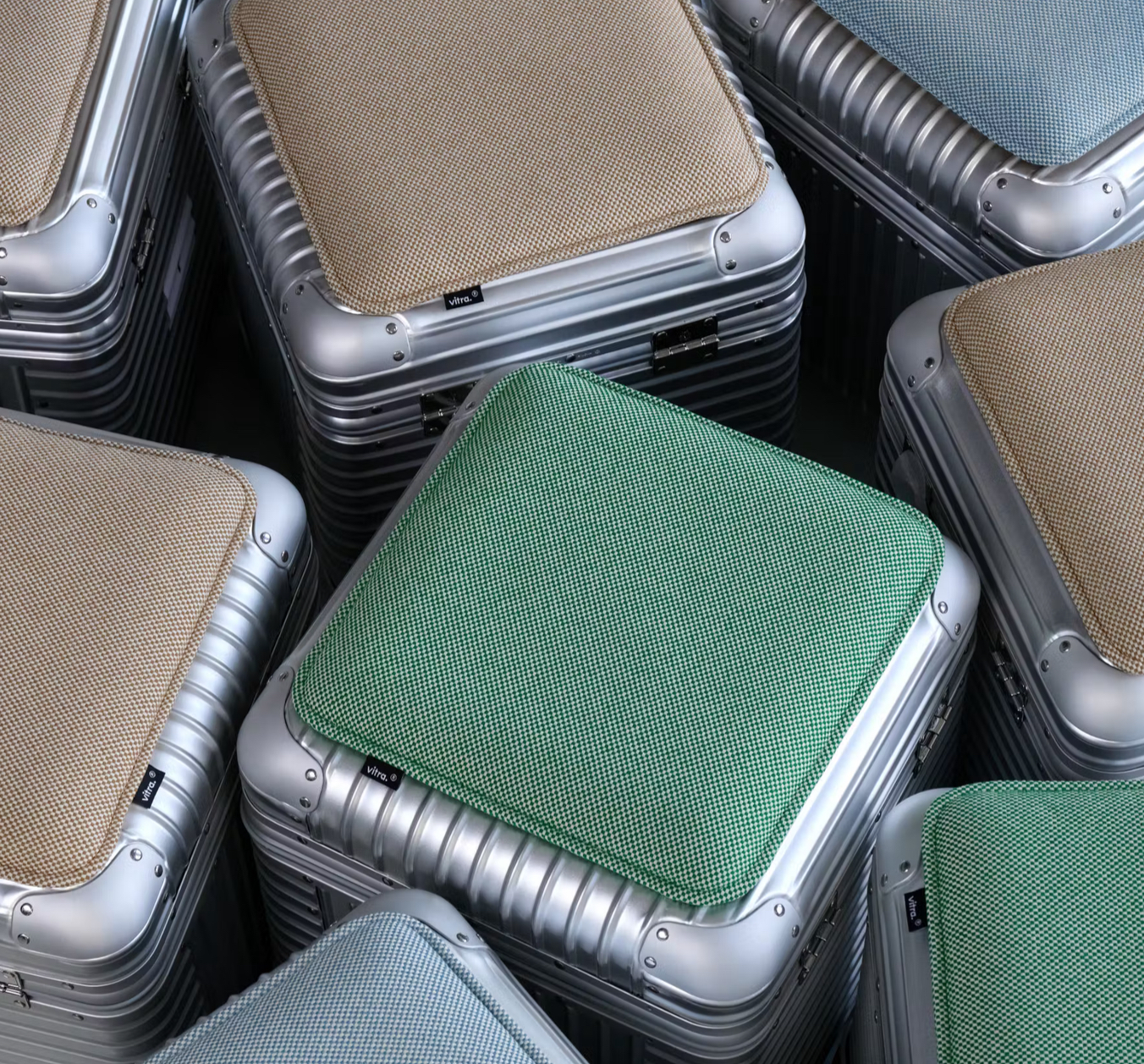 Upholstered Rimowa suitcases reimagined by Vitra as modular seating in green, beige, and blue