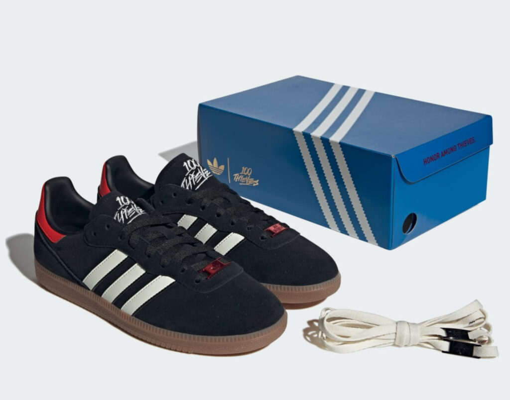 Adidas 100 Thieves Palos Hills shoe in black suede with gum sole, red heel detail, and branded blue box with extra laces