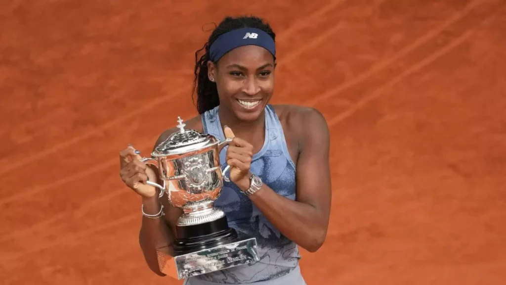 Coco Gauff celebrating victory on the clay court, holding trophy