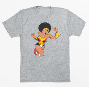 HARLEMUNDERGROUND Wonder Woman Tee featuring a Black superheroine in afro and armor, styled against a Harlem storefront backdrop