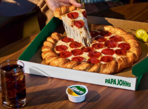 Papa John’s Croissant Pizza with golden, flaky crust and melted cheese, topped with pepperoni and served in a custom delivery box
