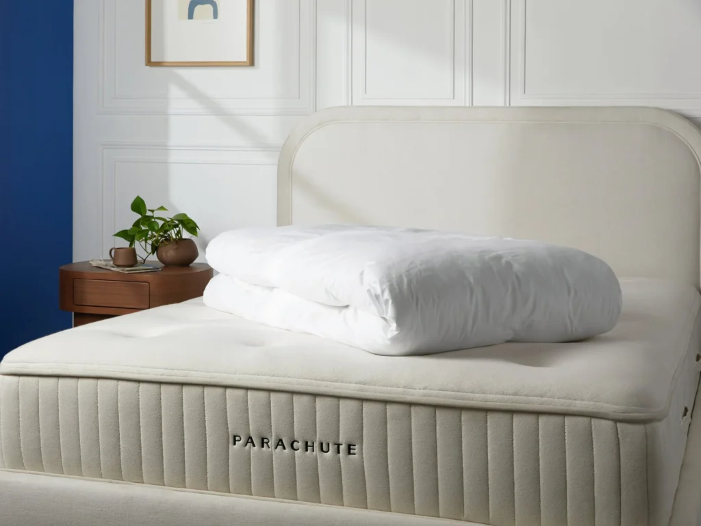 lush white down mattress topper on a bed with crisp sheets, evoking softness, comfort, and modern luxury sleep aesthetics
