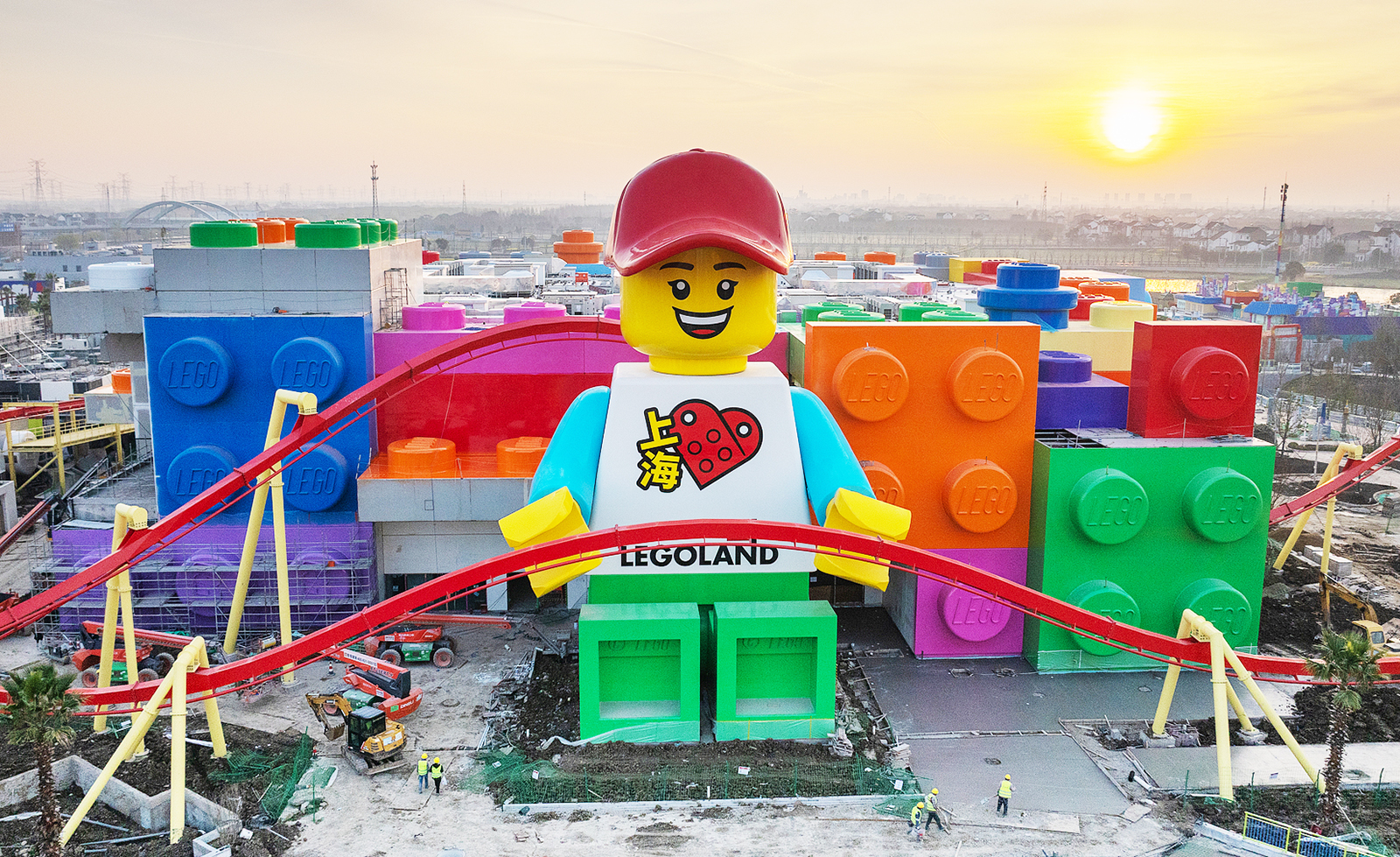 A vibrant aerial view of China’s first Legoland in Shanghai, showing colorful rides, Lego sculptures, and excited visitors