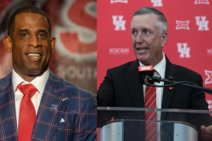 Deion Sanders and Willie Fritz standing side by side at a Big 12 conference event, both wearing formal suits and smiling, with a red backdrop featuring conference and university logos
