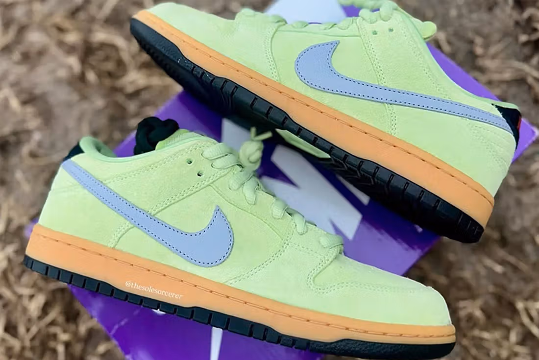Nike SB Dunk Low ‘Verdugo Mountain’ shoe featuring olive green suede overlays, tan leather panels, and a moss green Swoosh, displayed against a scenic outdoor-inspired background