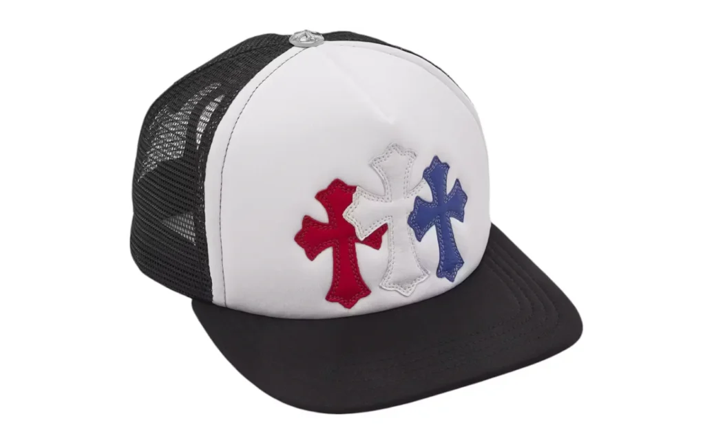 Front view of the Chrome Hearts Trucker Hat in blue, red, and white with gothic cross patch, symbolizing haute streetwear