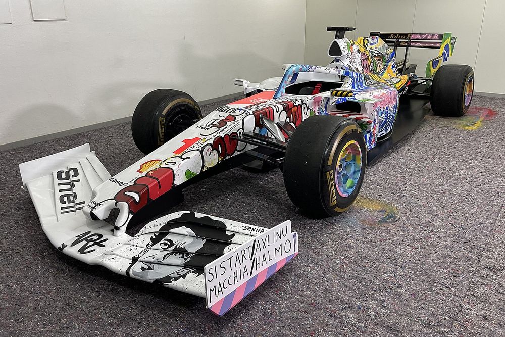 Slawn-designed Formula One art car featuring bold graffiti-style livery speeding on Silverstone track at British Grand Prix