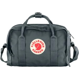 A dark grey Fjällräven Kånken Hip Pack Plus with top handles, an adjustable shoulder/waist strap, and the signature red fox circular logo on the front