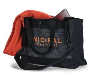 A sleek black Municipal All-Purpose Utility Bag shown on a city sidewalk, emphasizing its minimalist camouflage design and functional pockets