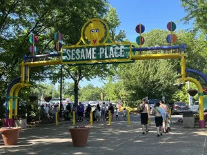Entrance archway of Sesame Place in Langhorne, Pennsylvania, featuring Big Bird on the sign, with families entering the park on a sunny summer day