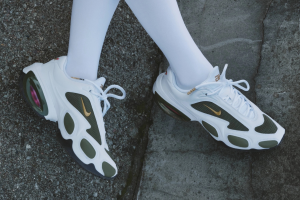 Veneda Carter x Nike Air Max Muse shoe, white and olive green design with gold accents, worn with white tights on concrete
