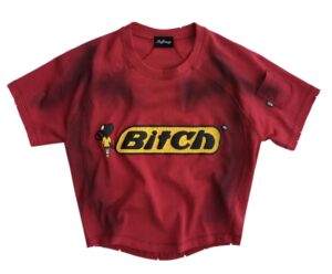 Red MADFRENZY ‘Bitch’ Tee with bold yellow cracked chest patch and raised black lettering, featuring a small cartoon-style female figure beside the logo.