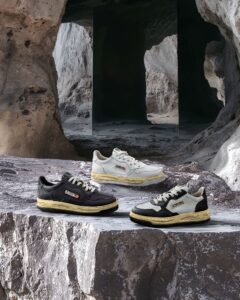 AUTRY x Maison Mihara Yasuhiro ‘Broken Something’ sneaker trio displayed on rocky terrain. The collection showcases three variations of the redesigned AUTRY Medalist, featuring Mihara’s signature hand-molded clay-inspired soles in black, white, and beige colorways against a cave-like natural backdrop