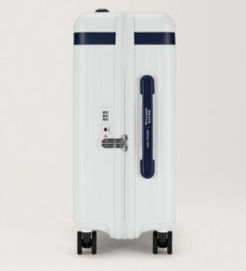 Side view of the Carl Friedrik x Williams Racing Atlassian carry-on suitcase in white with navy accents, featuring a built-in TSA lock, spinner wheels, and a side handle branded with Williams Racing and Carl Friedrik logos