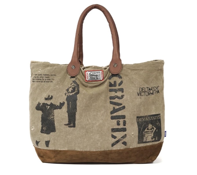 DEVA STATES SS25 Tote Bag ‘Canvas’ featuring khaki canvas body with bold black graphic prints, brown suede base, and leather handles, blending rugged utility with rebellious streetwear edge.