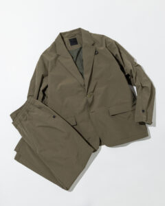 Olive green DAIWA PIER39 TECH LOOSE 2B JACKET paired with matching ripstop pants, a technical two-piece set blending outdoor durability with urban tailoring.