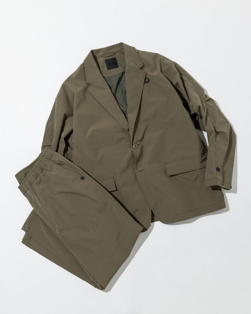 Olive green DAIWA PIER39 TECH LOOSE 2B JACKET paired with matching ripstop pants, a technical two-piece set blending outdoor durability with urban tailoring.