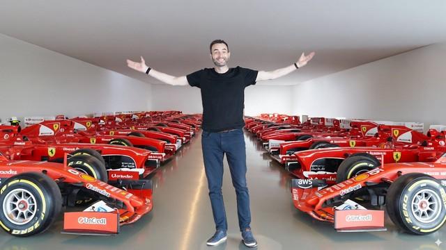 Former F1 driver Scott Mansell stands with arms outstretched inside Ferrari’s secret Formula 1 bunker, surrounded by rows of historic scarlet Ferrari race cars