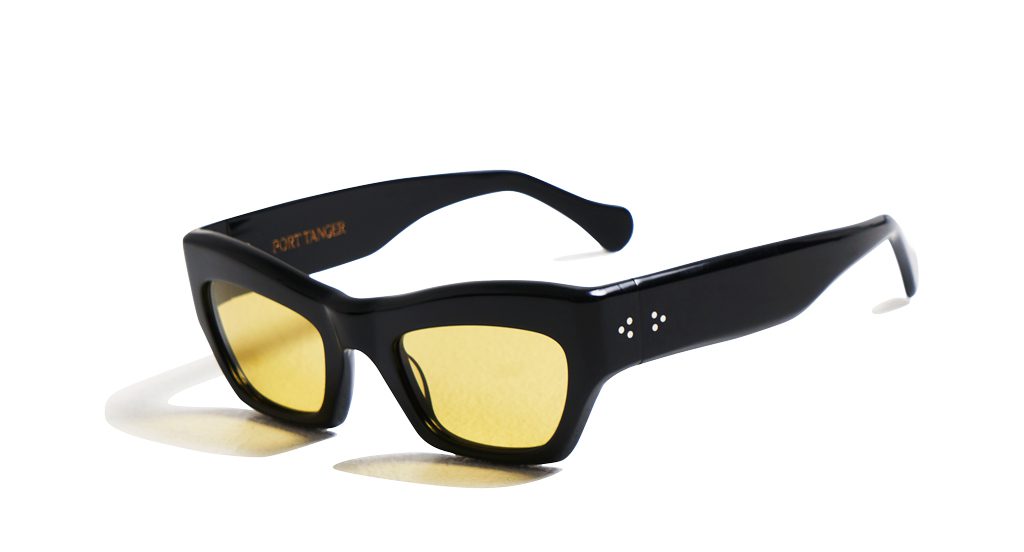 PORT TANGER Ayreen sunglasses with sleek black acetate frame and yellow-tinted rectangular lenses, shown against a white background.