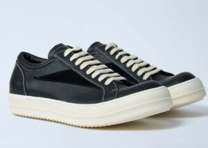 A pair of Rick Owens x LN-CC Exclusive Vintage Shoes in black leather with contrasting white stitching, beige laces, and chunky off-white rubber soles, showcasing a minimalist yet avant-garde design.