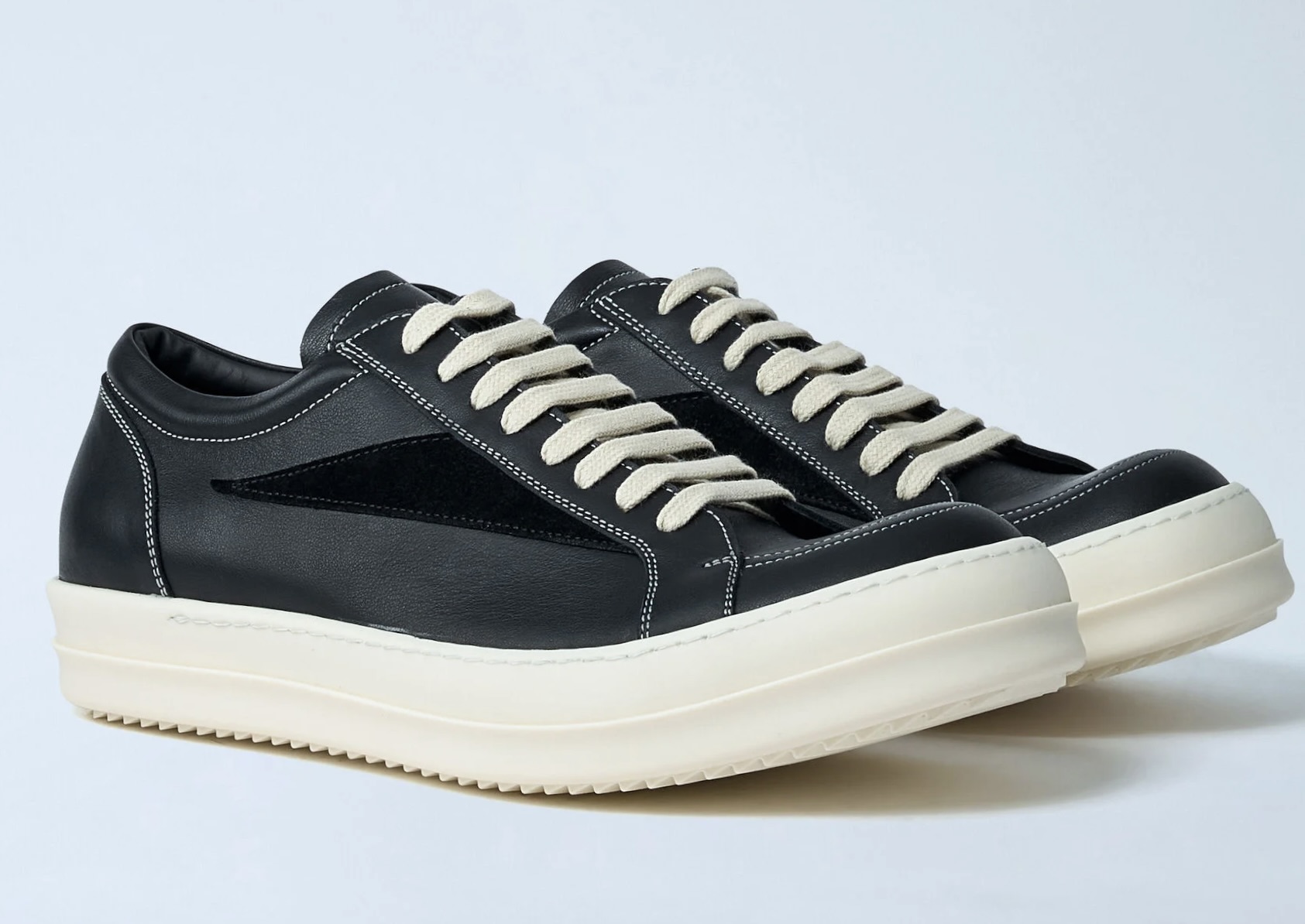 A pair of Rick Owens x LN-CC Exclusive Vintage Shoes in black leather with contrasting white stitching, beige laces, and chunky off-white rubber soles, showcasing a minimalist yet avant-garde design.
