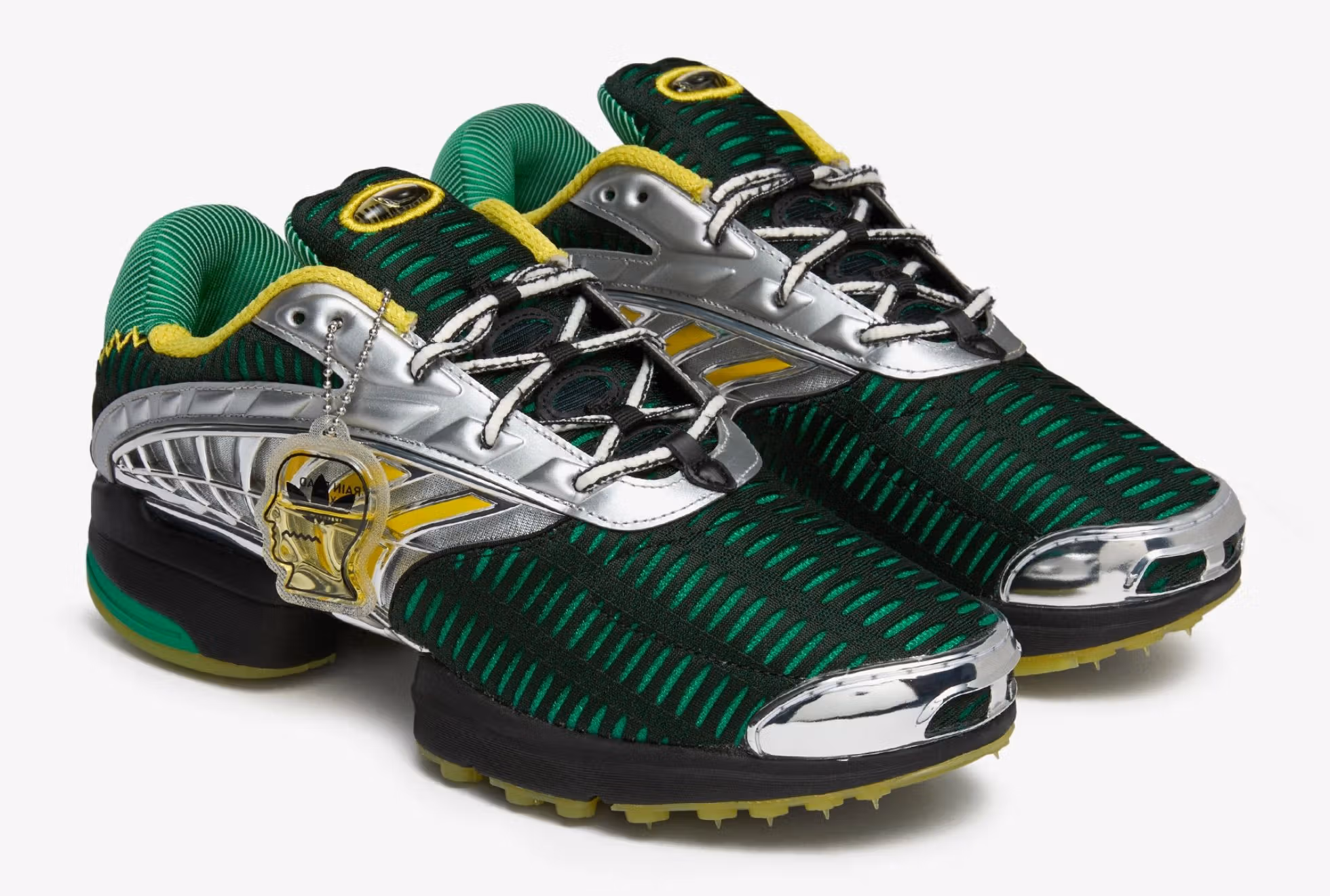 Image of the Brain Dead x adidas Climacool 2 sneaker in “Signal Green” colorway, photographed on a textured grey backdrop. The shoe features a ventilated mesh upper, sculpted TPU side ribs, and layered midsole vents. Brain Dead’s brain logo appears on the heel tab, while adidas’ three stripes are subtly integrated into the mesh structure. The design merges early-2000s tech aesthetics with Brain Dead’s experimental streetwear sensibility.