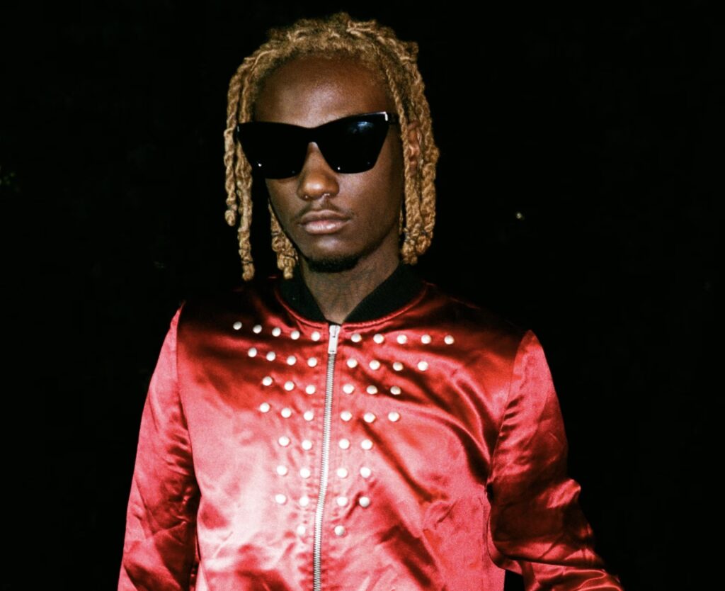 image of OsamaSon, wearing a red slim jacket with studded upon the front
