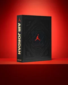 Air Jordan by Assouline — black embossed hardcover featuring the red Jumpman logo and gold spine typography, photographed against a vivid red gradient background.