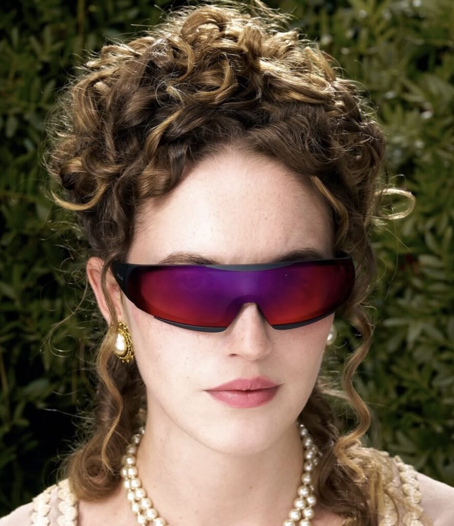 A woman wearing futuristic wrap-around sunglasses with iridescent purple lenses, styled with vintage curls, pearl jewelry, and gold earrings, blending classical elegance with modern sci-fi aesthetics.