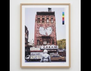 Framed artwork by American artist Scott Listfield depicting an astronaut facing a brick building with the Wu-Tang Clan logo painted on it, along with signage reading “C.R.E.A.M.” and “36 Chambers.” A yellow taxi and graffiti-covered van appear below, blending urban street culture with surreal exploration themes.