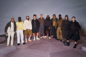 Models showcase the SR_A Engineered by ZARA Chapter Two collection designed by Samuel Ross, wearing layered neutral-toned outfits including technical outerwear, hooded tops, wide-leg trousers, and tailored shorts in shades of black, beige, khaki, and cream, reflecting the collection’s modern utilitarian and architectural aesthetic.