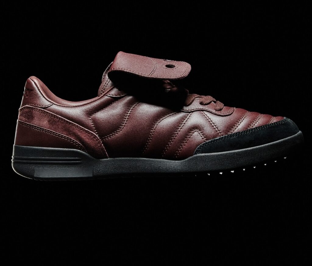 Saucony SILO Fall/Winter 2025 sneaker in rich currant red leather with black suede toe and sole, featuring quilted stitching and a fold-over lace guard, displayed against a black background.