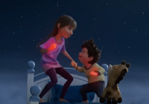 Stevie and Elliot from Netflix’s In Your Dreams standing on a bed under a starry night sky, holding glowing dream orbs, with their toy giraffe Baloney Tony beside them.
