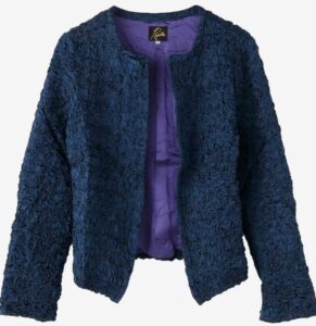 A blue textured collarless NEEDLES jacket with intricate satin embroidery and purple lining, photographed front-facing on a neutral background.