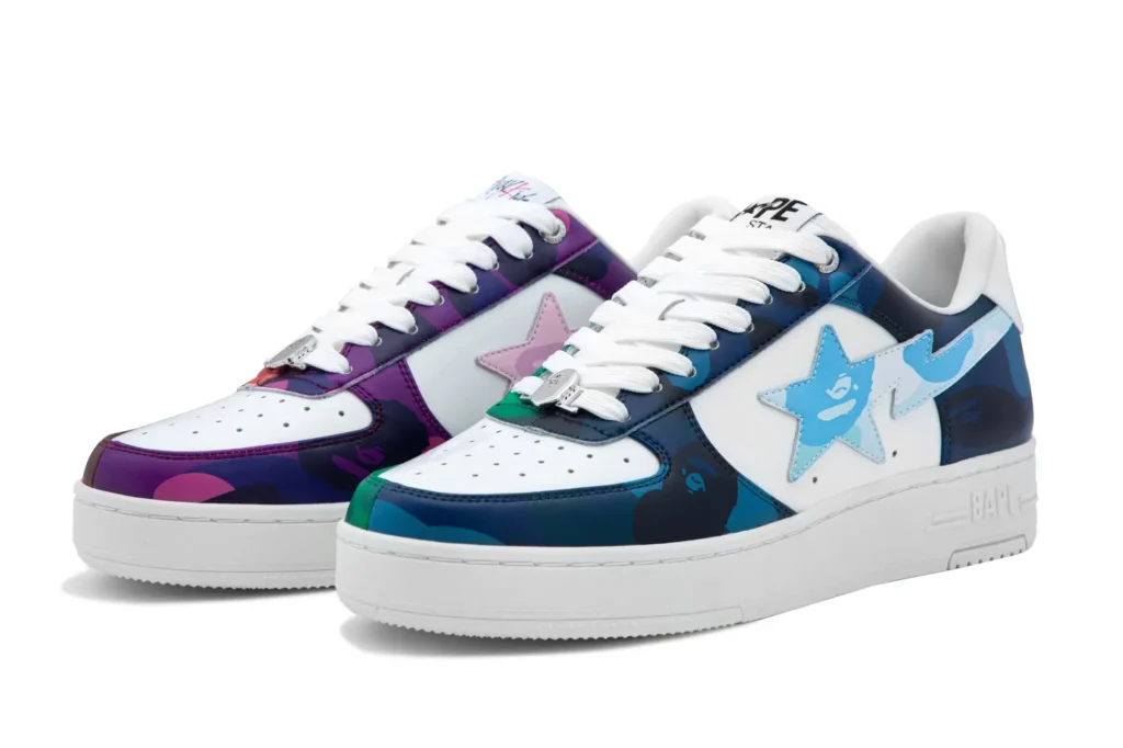 Close-up of the BAPE × Stray Kids BAPE STA sneakers featuring mismatched blue and purple camouflage overlays, glossy patent leather finish, and signature star logos on the sides. The design showcases Stray Kids’ vibrant color inspiration, combining BAPE’s streetwear heritage with the group’s youthful, performance-driven energy.