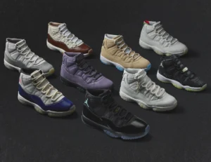 Lineup of nine Air Jordan 11 sneakers displayed on a black background, showcasing the 2025 30th anniversary releases in grey, brown, wheat, purple, white, navy, and black colorways.