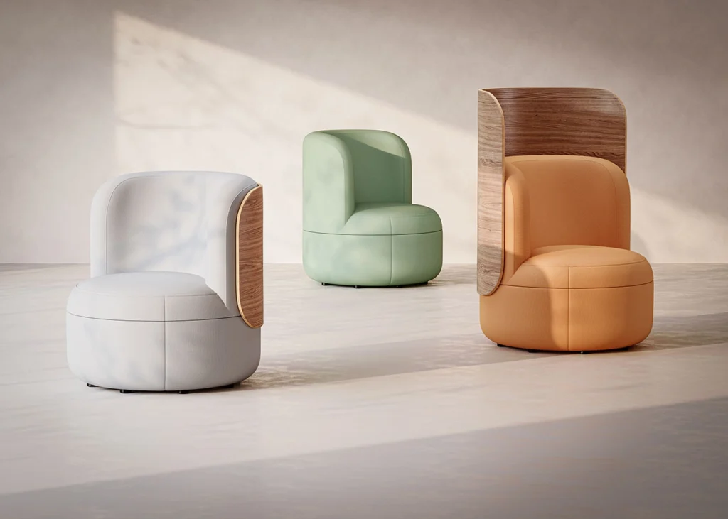 Three lounge chairs from KFI Studios’ expanded Dotti Collection are displayed in a softly lit minimalist setting. The chairs feature smooth, rounded silhouettes in pastel hues — light gray, mint green, and warm orange. Two of the chairs incorporate curved wooden back panels that wrap partially around the upholstery, highlighting the blend of natural materials and contemporary form. The arrangement showcases the collection’s variety in color, texture, and back design options.